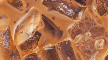 Up close image of square ice cubes inside coffee