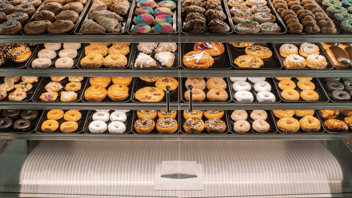 Looking into Structural Concepts bakery case with two doors. Behind glass doors are trays of donuts, pastries, and scones. 