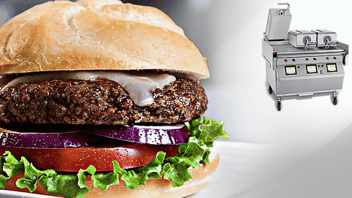 In forefront - hamburger with white cheese, purple onion slices, tomato, and lettuce on bun. Background is a Taylor clamshell griddle.