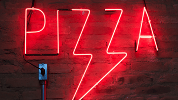 neon light that says pizza